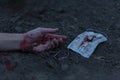 A medical bloodied mask lies on the ground with a bloody hand reaching out. The concept of coronavirus and the apocalypse