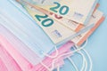 Medical blue, pink masks and euro money.Soft focus.Close up.Concept of expensive purchase, deficit, protection against viruses,