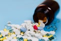 Medical bottle and medication pills spilling out on to pastel blue background. Healthcare, pharmacy, medicine concept Royalty Free Stock Photo