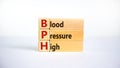 Medical and BPH, Blood Pressure High symbol. Wooden blocks with the word `BPH, Blood Pressure High`. Beautiful white background. Royalty Free Stock Photo