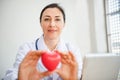 Medical Cardiologist Doctor is Holding Red Heart Give to Patient, Female Physician Doctor Showing Heart Model to Her Patients in