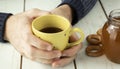 Medical care concept - hands holding cup with ginger honey and lemon tea with drugs, pills and spray Royalty Free Stock Photo