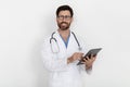 Medical Care. Handsome Smiling Doctor Man In Uniform With Clipboard In Hands Royalty Free Stock Photo