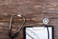 Medical clipboard and stethoscope on dark wooden table. Royalty Free Stock Photo