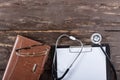 Medical clipboard and stethoscope on dark wooden table. Royalty Free Stock Photo