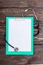 Medical clipboard and stethoscope on dark wooden table. Royalty Free Stock Photo