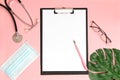 Medical clipboard, stethoscope, monstera sheet, goggles and face shield on a pink background. Medical banner template with copy Royalty Free Stock Photo