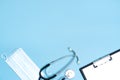 Medical clipboard, stethoscope, protective mask on a blue background. Medical banner template with copy space, header layout. Royalty Free Stock Photo