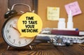 On the alarm clock a sticker with the inscription - Time to take your medicine Royalty Free Stock Photo