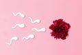 Medical concept of artificial insemination. In vitro fertilization. Red peony flower with plastic sperm forms Royalty Free Stock Photo