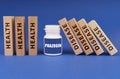 Medical concept. On a blue background, wooden dies, a white jar with the inscription - Prazosin