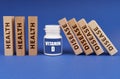 Medical concept. On a blue background, wooden dies, a white jar with the inscription - Vitamin D