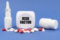 On the blue surface of the pill, capsule, spray, jar and cube with the inscription - RISK FACTOR