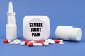 On the blue surface of the pill, capsule, spray, jar and cube with the inscription - severe joint pain