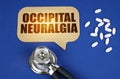 On the blue surface of the tablet, a stethoscope and a cardboard sign with the inscription - Occipital neuralgia