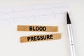 On the cardiogram lies a pen and torn paper with the text - Blood pressure Royalty Free Stock Photo