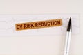 On the cardiogram lies a pen and torn paper with the text - CV Risk Reduction