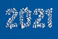 Medical concept congratulations on the year 2021. A lot of pills scattered on a blue background in the shape of the number 2021.