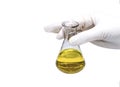 Medical concept: doctor`s hand in rubber glove holding chemical flask with yellow liquid Royalty Free Stock Photo