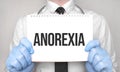 Medical concept. Doctor is writing the word anorexia on white paper notepad