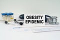 On the medical documents there is a stethoscope, syringe and a business card with the inscription - obesity epidemic