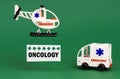 On a green surface, an ambulance car and a helicopter with a sign - ONCOLOGY Royalty Free Stock Photo