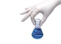 Medical concept: hand in rubber glove holding flask with blue liquid Royalty Free Stock Photo