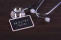 Medical Concept-Healthy MEAL words written on label tag with Stethoscope on wood background. Royalty Free Stock Photo