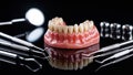Medical Concept Image of Denture with Fractured Front Teeth and Scattered Dental Tools on Glossy Black Surface Royalty Free Stock Photo