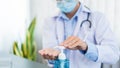 Medical concept a male doctor wearing mask and using hand sanitizer alcohol gel for preventing against infection of Coronavirus Royalty Free Stock Photo