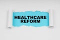 In the middle of a white sheet in space on a blue background the inscription - HEALTHCARE REFORM Royalty Free Stock Photo