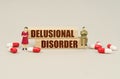 Next to the miniature figurines of people are tablets and wooden blocks with the inscription - Delusional Disorder