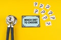 On a yellow background, a stethoscope, question marks and a sticker with the inscription - Which diet to choose