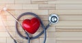 Medical concept, red heart and stethoscope on wooden background.