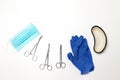 Stainless steel medical grade needle holder clamps, blue latex gloves, metal container on gray background Royalty Free Stock Photo