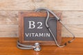 stethoscope and blackboard with text & x22;Vitamin B2& x22; on wooden background Royalty Free Stock Photo