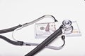 Medical concept - stethoscope over the dollar bills  on white background. Royalty Free Stock Photo