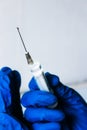 Medical concept. Syringe held by a doctor with blue gloves.  Medical syringe in a hand with a blue glove Royalty Free Stock Photo