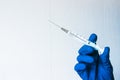 Medical concept. Syringe held by a doctor with blue gloves.  Medical syringe in a hand with a blue glove Royalty Free Stock Photo