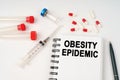 On the table are pills, injections, a syringe and a notepad with the inscription - obesity epidemic Royalty Free Stock Photo