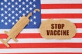 On the US flag there is a cardboard figure of a syringe and a torn cardboard with the inscription - STOP VACCINE