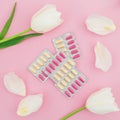 Medical concept with vitamins pills and white flowers on pink background. Flat lay Royalty Free Stock Photo