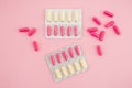 Medical concept with vitamins pills and white flowers on pink background. Flat lay, top view. Royalty Free Stock Photo