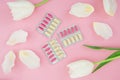 Medical concept with vitamins pills and white flowers on pink background. Flat lay, top view. Royalty Free Stock Photo