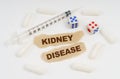 On a white surface lies a syringe, pills, dice and pieces of paper with the inscription - KIDNEY DISEASE Royalty Free Stock Photo