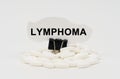 On a white surface are pills and torn paper with the inscription - LYMPHOMA Royalty Free Stock Photo