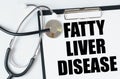 On a white surface, a stethoscope and a tablet with an inscription - FATTY LIVER DISEASE