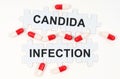 On a white surface, tablets and puzzles with the inscription - Candida Infection
