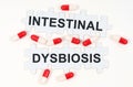 On a white surface, tablets and puzzles with the inscription - INTESTINAL DYSBIOSIS