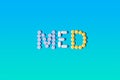 Medical concept. The word MED made from pills of different shapes and colors on a gradient blue and green background